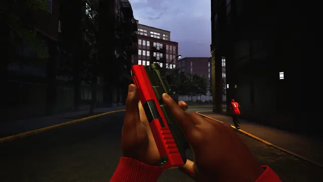 A red handgun viewed along a dark city street