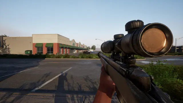 Scoped rifle overlooking a road and low commercial buildings